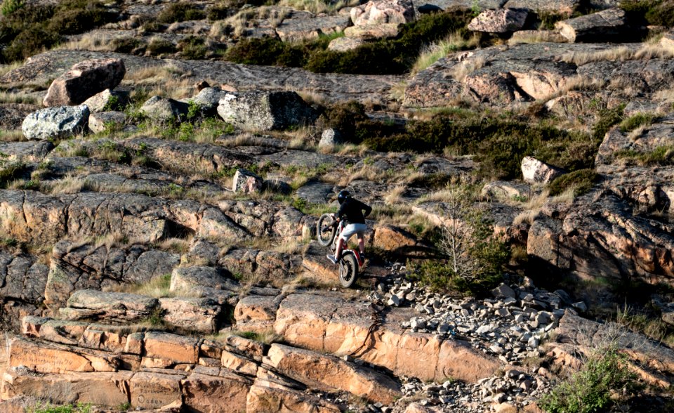 Boy on motocross bike going up the cliffs in Govik