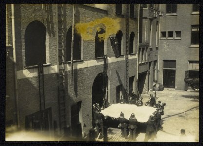 Brandweeroefening met vangzeil op de binnenplaats van een gebouw., Bestanddeelnr 158-1330