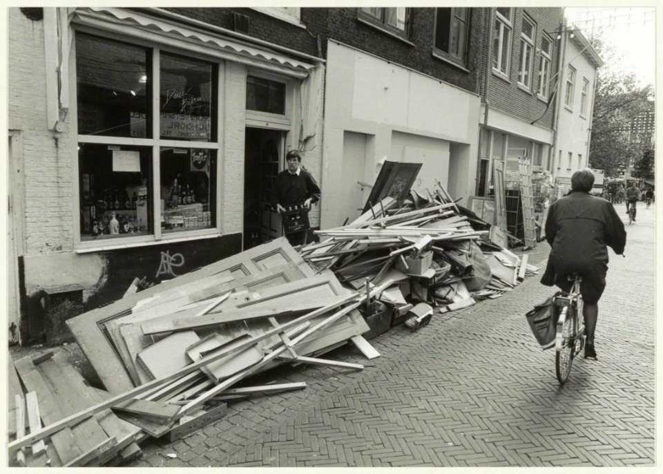 Bouwactiviteiten in de Grote Houtstraat en de rotzooi belandt voor de deuren in de Gierstraat, tot woede van de winkeliers aldaar. Links op de foto de voormalige bierwinkel Deux Bieres. NL-HlmNHA 54031739