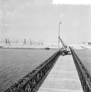 Bouw Baileybruggen in het Haringvliet, plaatsen van de lantaarns op de brug, Bestanddeelnr 910-6184
