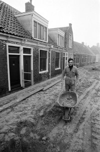 Bouwvakker met een kruiwagen in een straatje in het Zuiderzeemuseum, Bestanddeelnr 931-2876