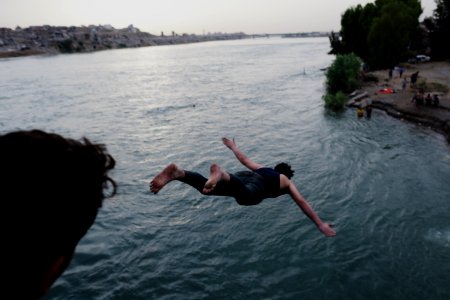Boys playing and diving at the Old Bridge over the Tigris in Mosul in 2019 during the summertime 11