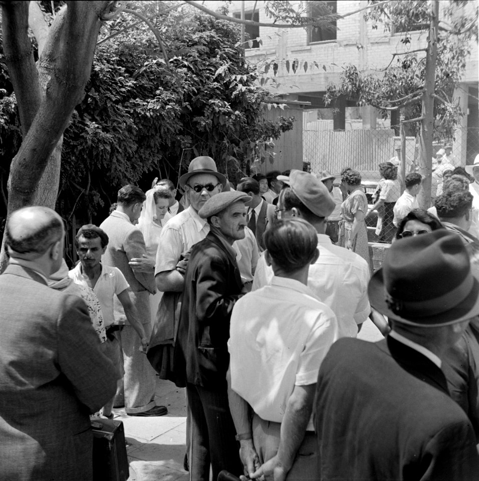 Bruiloftsgasten met op de achtergrond een bruid, vermoedelijk in Haifa, Bestanddeelnr 255-0307