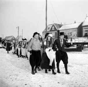 Bruidspaar en bruiloftsgasten, allen in klederdracht lopen door de sneeuw De br, Bestanddeelnr 254-1940