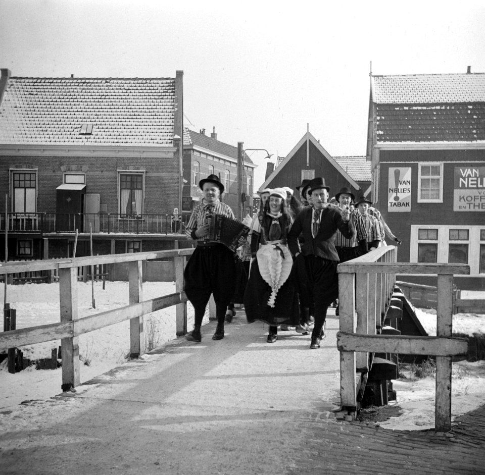 Bruidspaar met daarachter een muziekkorps lopen over een brug, allen in klederdr, Bestanddeelnr 254-1935