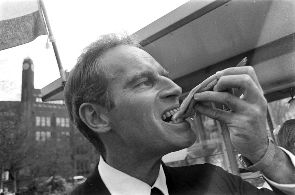 Charlton Heston in Amsterdam. Hier eet hij een haring, Bestanddeelnr 921-2290