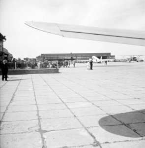 Café-terras De wijde blik met op de achtergrond een grote hangar en een gepark, Bestanddeelnr 254-2413