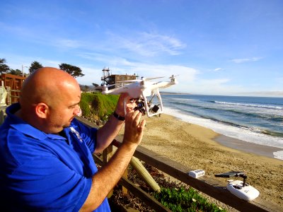 California photo of drone operator with drone near Pacific Ocean