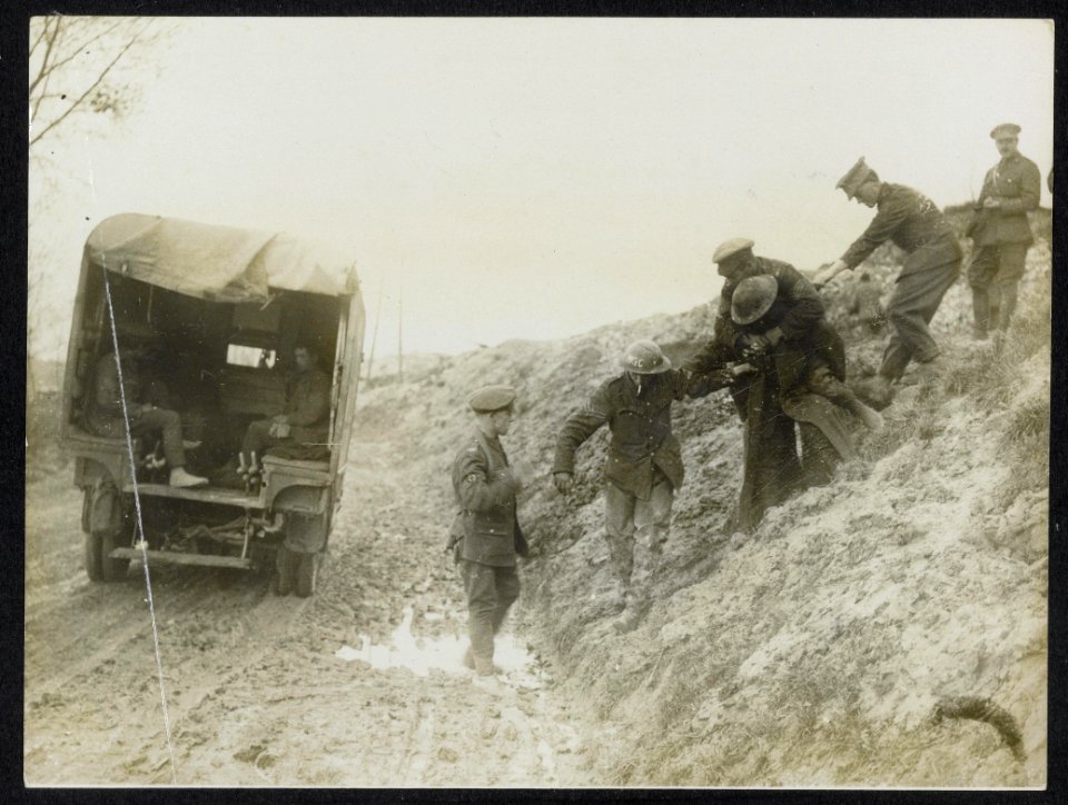 Carrying a wounded man down to an ambulance, Bestanddeelnr 158-0980