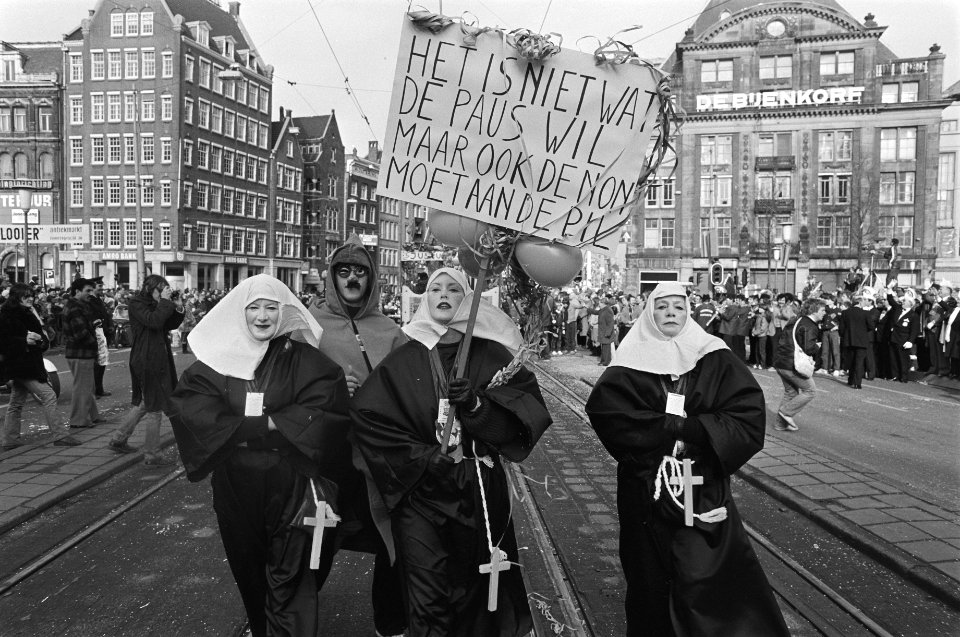 Carnavalsoptocht door centrum Amsterdam, als nonnen verklede mensen droegen dit bord mee Het is niet wat de paus wil, maar ook de non moet aan de pil, Bestanddeelnr 931-3502