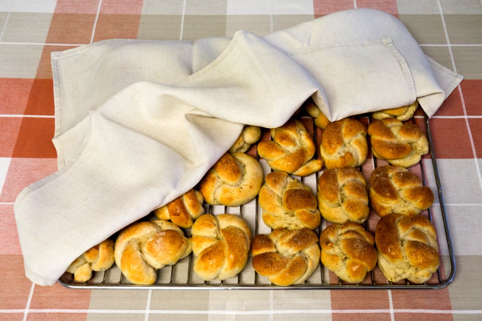 Cardamom buns on grate under towel