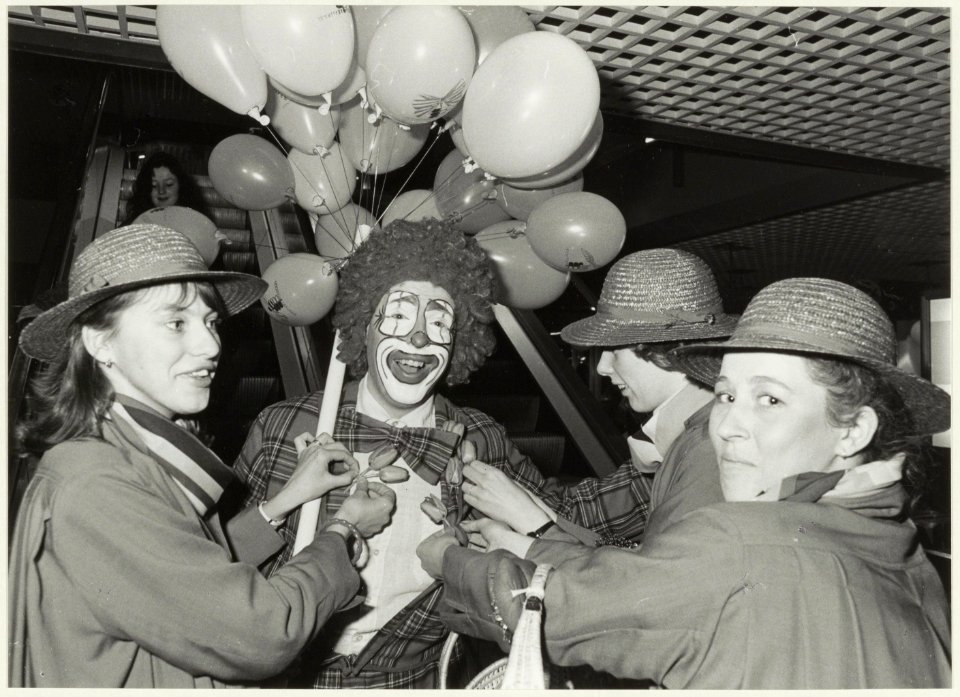 Clown Hakim met bloemenmeisjes t.g.v. het 3-jarig bestaan van de Brinkmann-passage . NL-HlmNHA 54025919