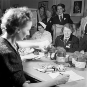 Collectebussen worden geleegd en de inhoud geteld door een aantal vrouwen rond e, Bestanddeelnr 900-7205