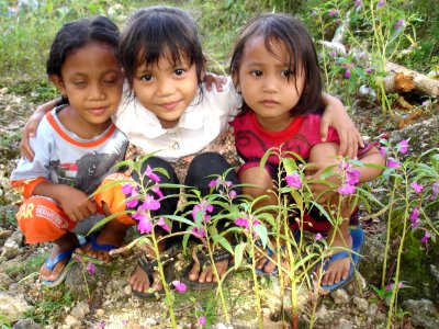 Children with garden balsam (Impatiens balsamina)