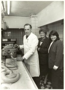 Chef worstenmaker W.C.Roosen bij slagerij Broekhof. Rechts wethouder Loeki van Balen. NL-HlmNHA 54031547