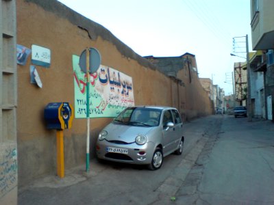 Chery QQ Parked near thatch wall - walpaintig - Morning -