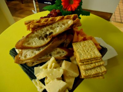 Cheese and crackers with a flower on a table with a yellow tablecloth