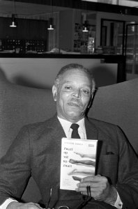 Chester Himes met zijn nieuwe boek Zwart op Wit, Bestanddeelnr 920-7572