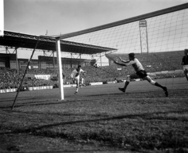 Cruijff terwijl hij eerste doelpunt voor Ajax scoort. Rechts keeper Jongbloed, Bestanddeelnr 918-3529