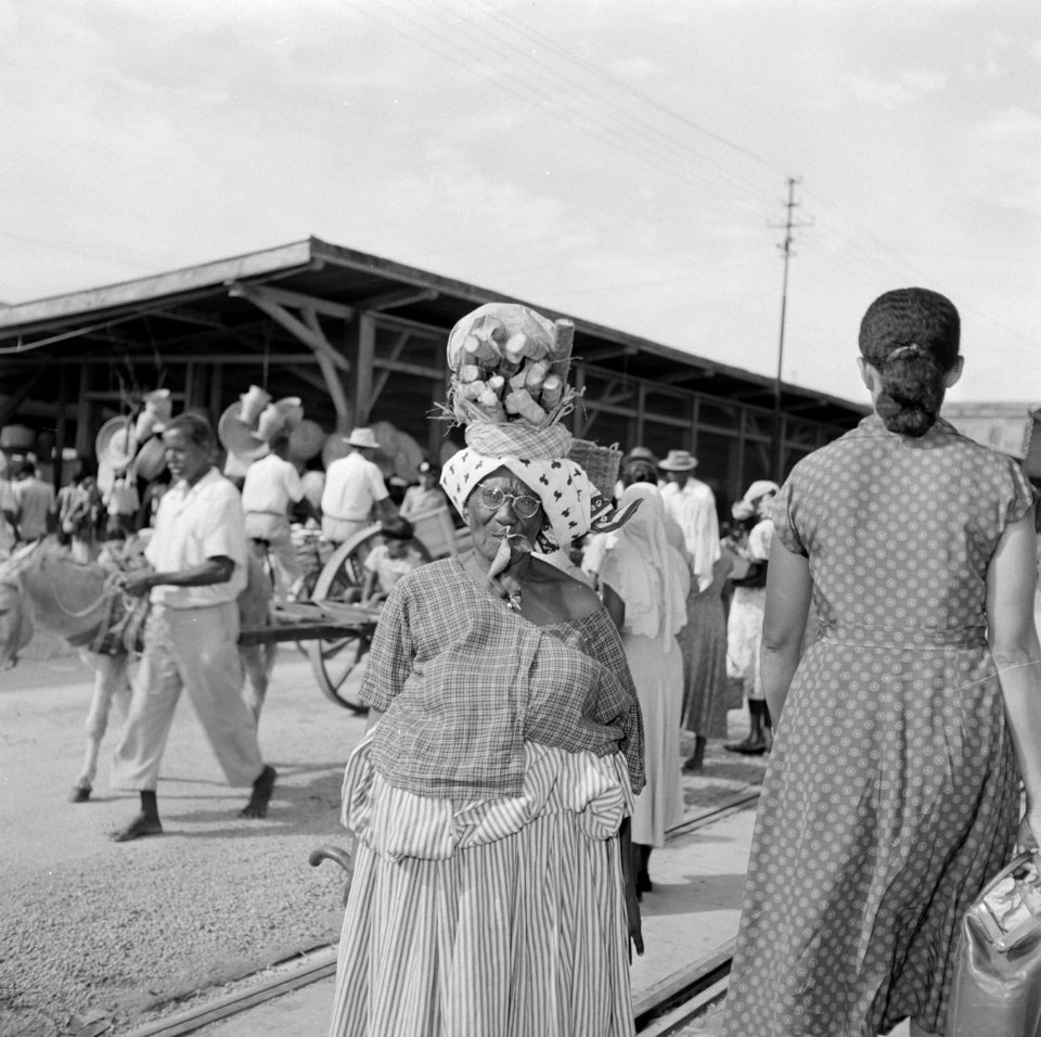 Creoolse vrouw met houtbundel op haar hoofd bij een markt in Paramaribo, Bestanddeelnr 252-4964