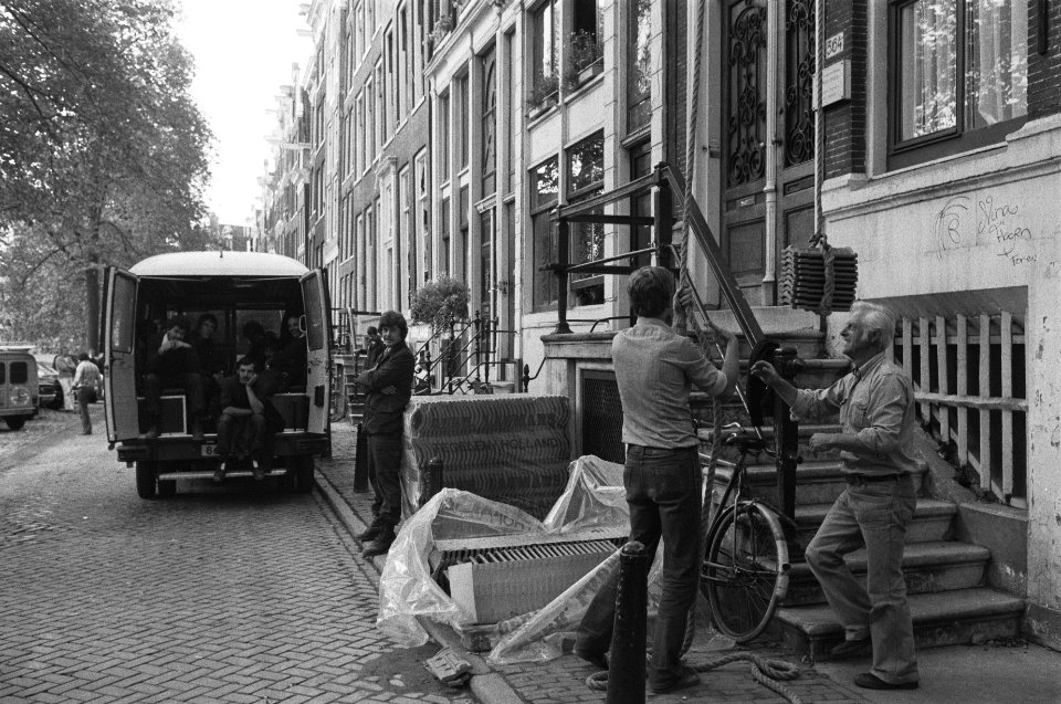 Dakpannen worden naar boven gehesen onder toezicht van ME, Bestanddeelnr 931-0084