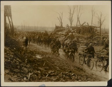 Cyclists & Cavalry passing through a recently captured village, Bestanddeelnr 158-2404