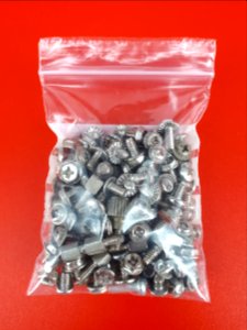Computer screws in a zipper storage bag - 6 x 9 cm - on Red plastic