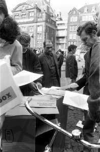 Communicatie-enveloppen worden uitgedeeld op de Dam, Amsterdam de politie arres, Bestanddeelnr 922-7458