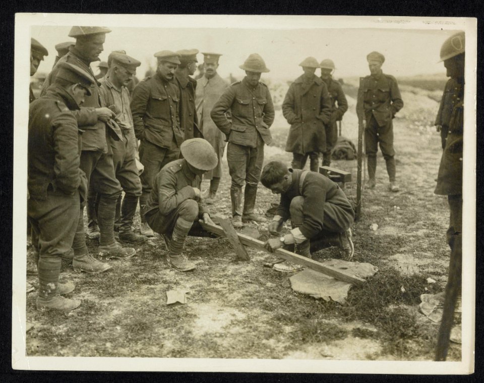 Comrades making a simple cross for chums grave, Bestanddeelnr 158-1132