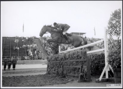 Concours Hippique Een ruiter met een springpaard neemt een hindernis, Bestanddeelnr 156-1339