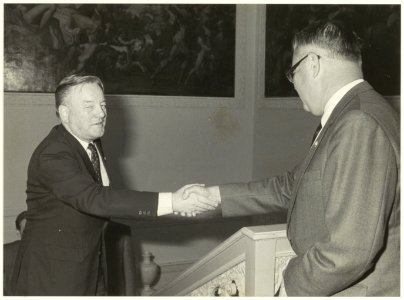 Commissaris der Koningin, drs. R.J. de Wit (rechts) schudt de hand van een onbekend persoon in het Provinciehuis. NL-HlmNHA 54020953