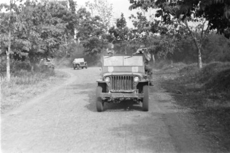 Colonne jeeps. Rechts probeert een man een foto te nemen, Bestanddeelnr 59-4-5