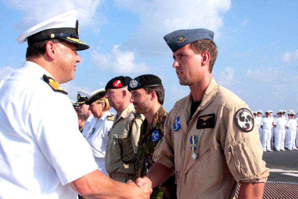 Commandeur-lenselink-feliciteert-een-militair-van-de-luchtmacht-met-de-medaille-terwijl-vertegenwoordigers-van-landmacht