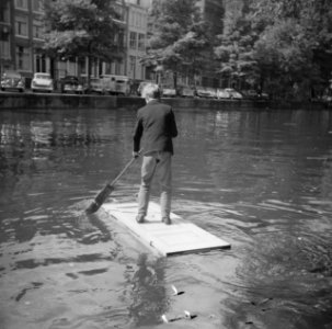 Cor Mudink vaart op zelfgemaakt vlot door de Prinsengracht, Bestanddeelnr 911-5157