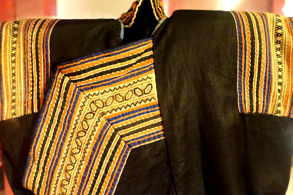 Costume detail, Hmong Den, Hoa Binh, 1950, view 1, handmade and industrial cotton, hemp, batik patterns, embroidery, applique - Vietnamese Women's Museum - Hanoi, Vietnam - DSC03788