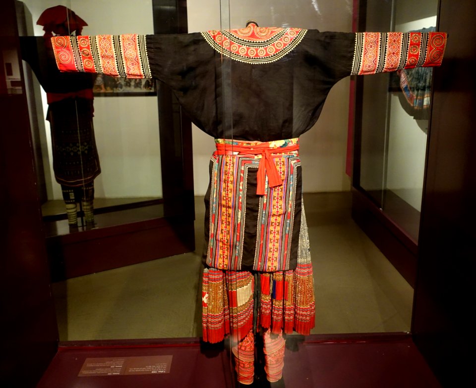 Costume, Hmong Hoa, Lao Cai, 1950, view 1, gown and apron in industrial cotton, skirt in three panels of help, trimmed in batik patterns - Vietnamese Women's Museum - Hanoi, Vietnam - DSC03767