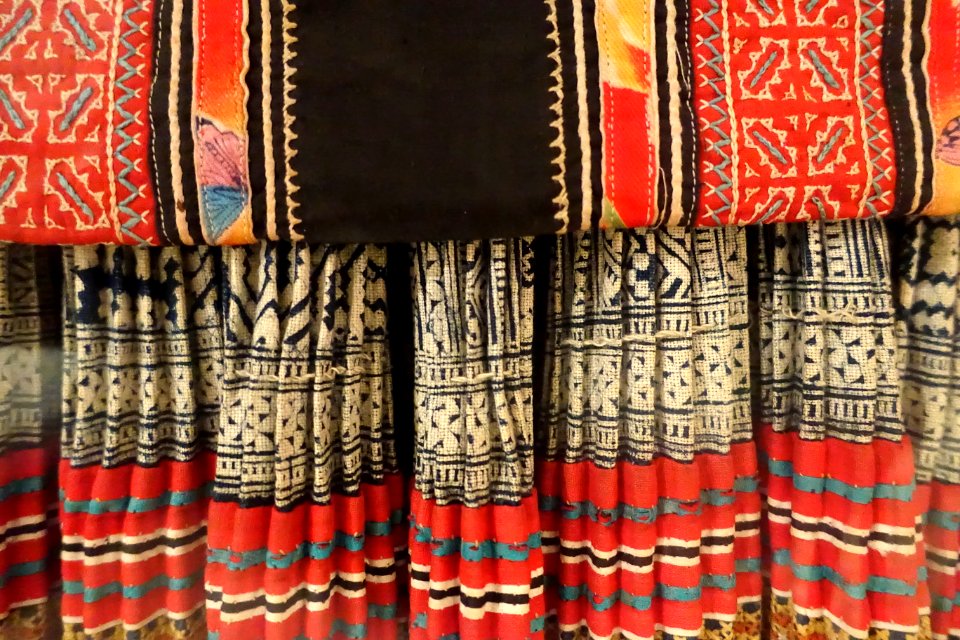 Costume, Hmong Hoa, Lao Cai, 1950, view 4, gown and apron in industrial cotton, skirt in three panels of help, trimmed in batik patterns - Vietnamese Women's Museum - Hanoi, Vietnam - DSC03762