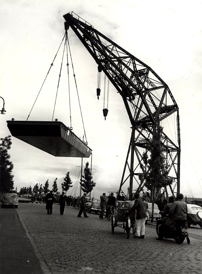 Conrad Stork. De drijvende kraan (drijvende Bok) met een last aan de Spaarndamseweg, nabij de Floresstraat ziende naar het noorden. Aangekocht in 1977 van fotograaf C. de Boer. Identificatie, NL-HlmNHA 54010641