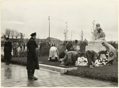 Deelnemers aan de Hannie Schaft Herdenking leggen een krans bij het oorlogsmonument aan de Rijksstraatweg
