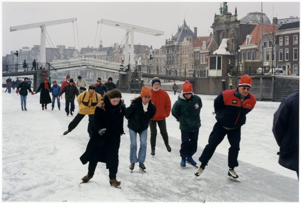 Deelnemers aan de Haarlems Dagblad-toertocht schaatsen over het Spaarne bij de Gravestenenbrug, ziende naar het oosten. NL-HlmNHA 54036297