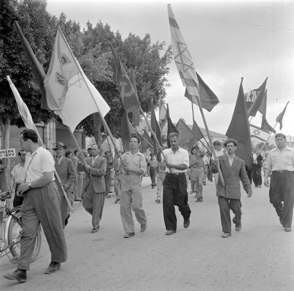 Deelnemers aan een 1 mei demonstratie (Dag van de Arbeid), zwaaiend met vlaggen, Bestanddeelnr 255-0168