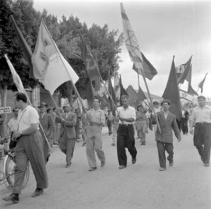 Deelnemers aan een 1 mei demonstratie (Dag van de Arbeid), zwaaiend met vlaggen, Bestanddeelnr 255-0168
