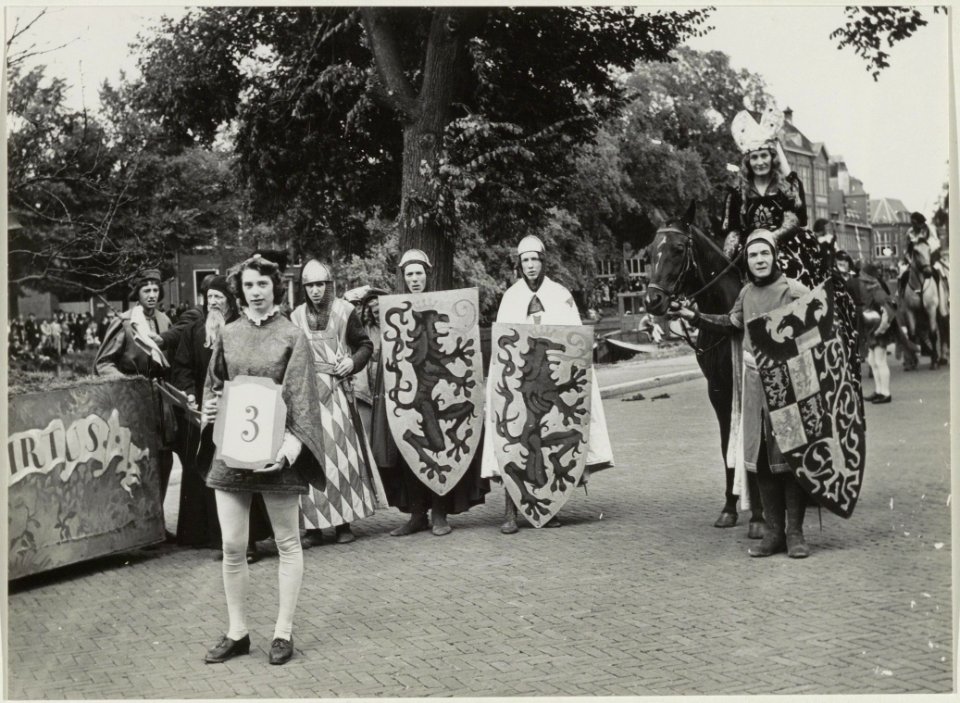 Deelnemers aan de Historisch-Allegorische optocht t.g.v. het 700-jarig bestaan van Haarlem beelden Jacoba van Beieren met haar schildknapen uit. NL-HlmNHA 54011103