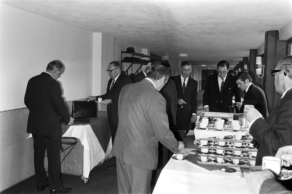 Deelnemers aan de vergadering bij de tafel met koffie, Bestanddeelnr 924-3766