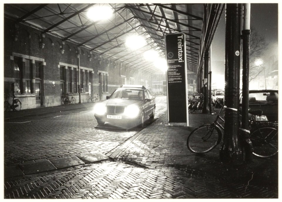 De voormalige taxistandplaats onder de rijtuigkap op het Stationsplein. NL-HlmNHA 54031888