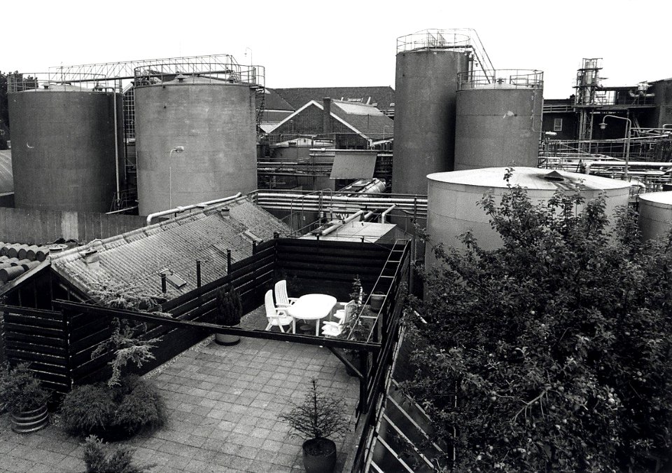 De Witco fabriek knel in een woonbuurt. Aangekocht van United Photos de Boer bv. - Negatiefnummer 36653 k 2a. - Gepubliceerd in het Haarlems Dagblad van 11.07.1992. Identificatienummer 54-033985