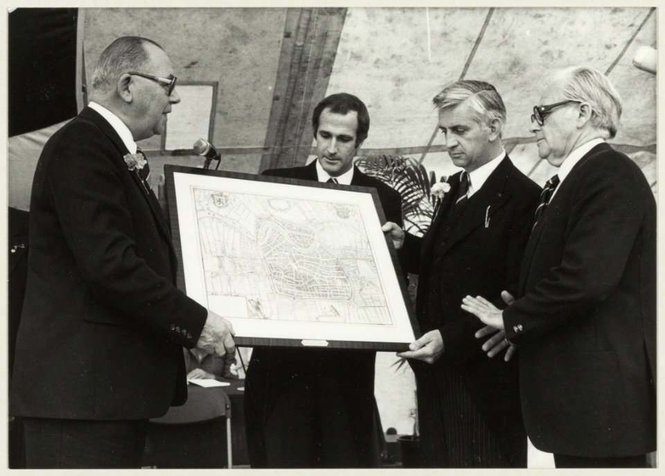 De voorzitter van de KNVB, W. Meuleman, overhandigt zijn cadeau, een oude plattegrond van Haarlem, aan K.H.F.C voorzitter D.A. Oud (tweede van rechts). NL-HlmNHA 54010027