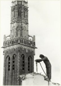 Deel van de toren van de Bakenesserkerk met op de voorgrond een werkman bevonop een slooppand aan de Bakenessergracht. NL-HlmNHA 54023292