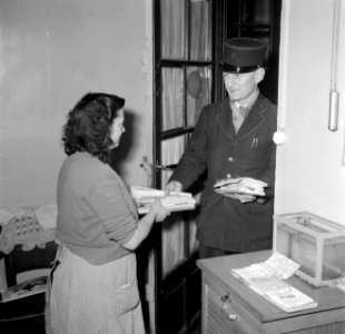 De postbode komt het kantoortje van de conciërge binnen, Bestanddeelnr 252-9305