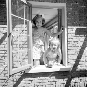 De prinsessen Irene en Margriet kijken uit een openstaand raam van het zomerhuis, Bestanddeelnr 255-7886